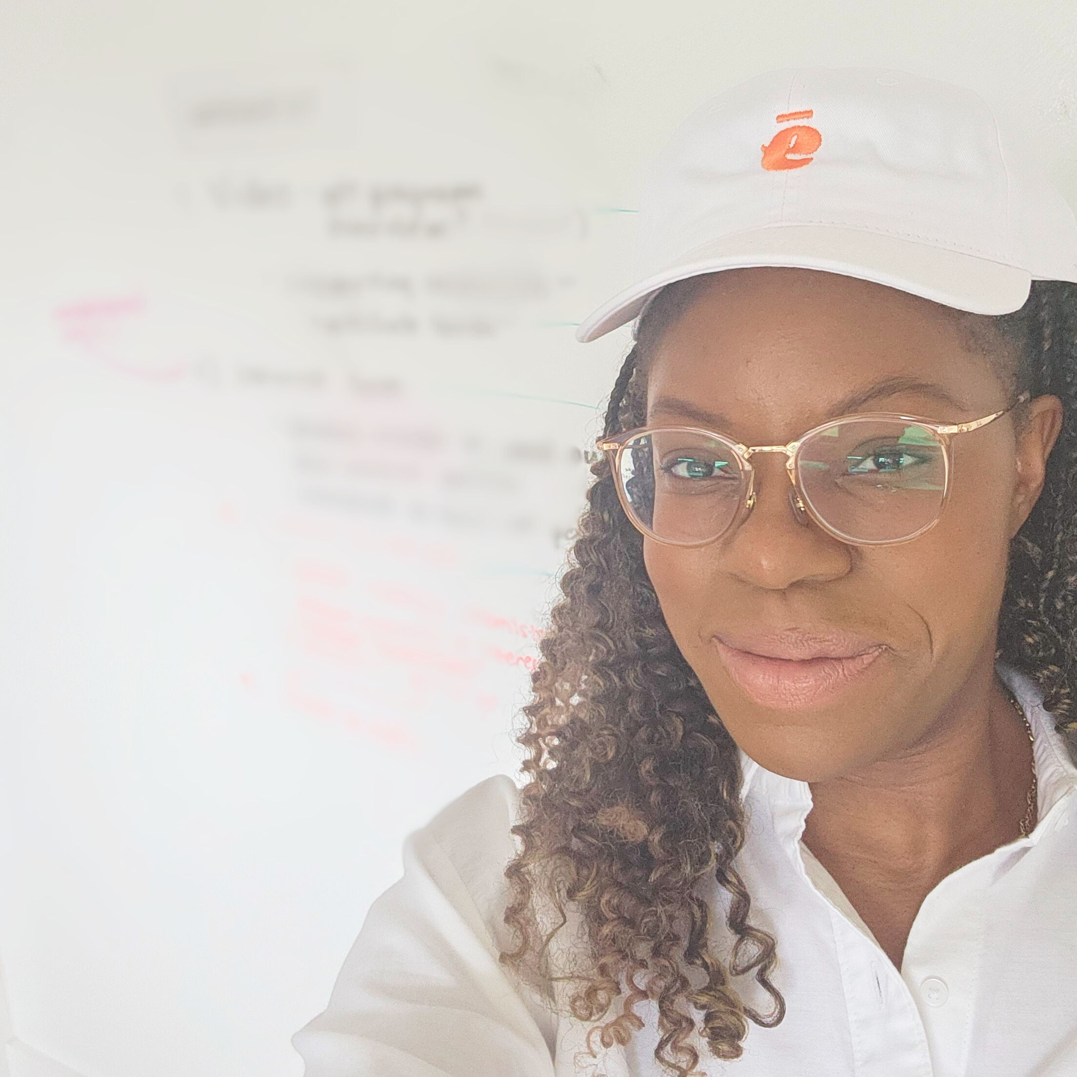 Photo of Enoma at EMA Headquarters collaborating in front of a blurred out whiteboard